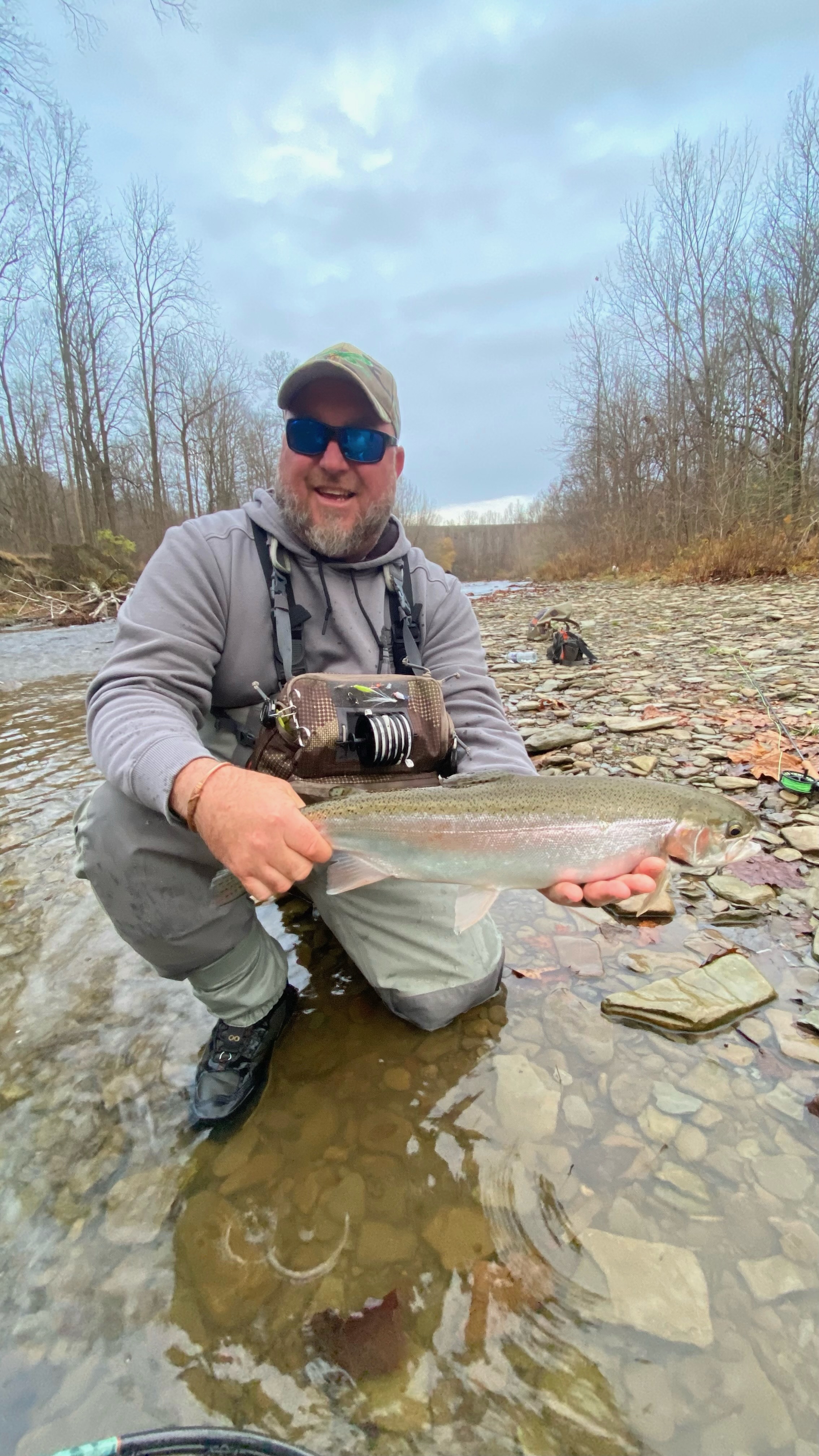 Angler proudly displaying a freshly caught fish on the river